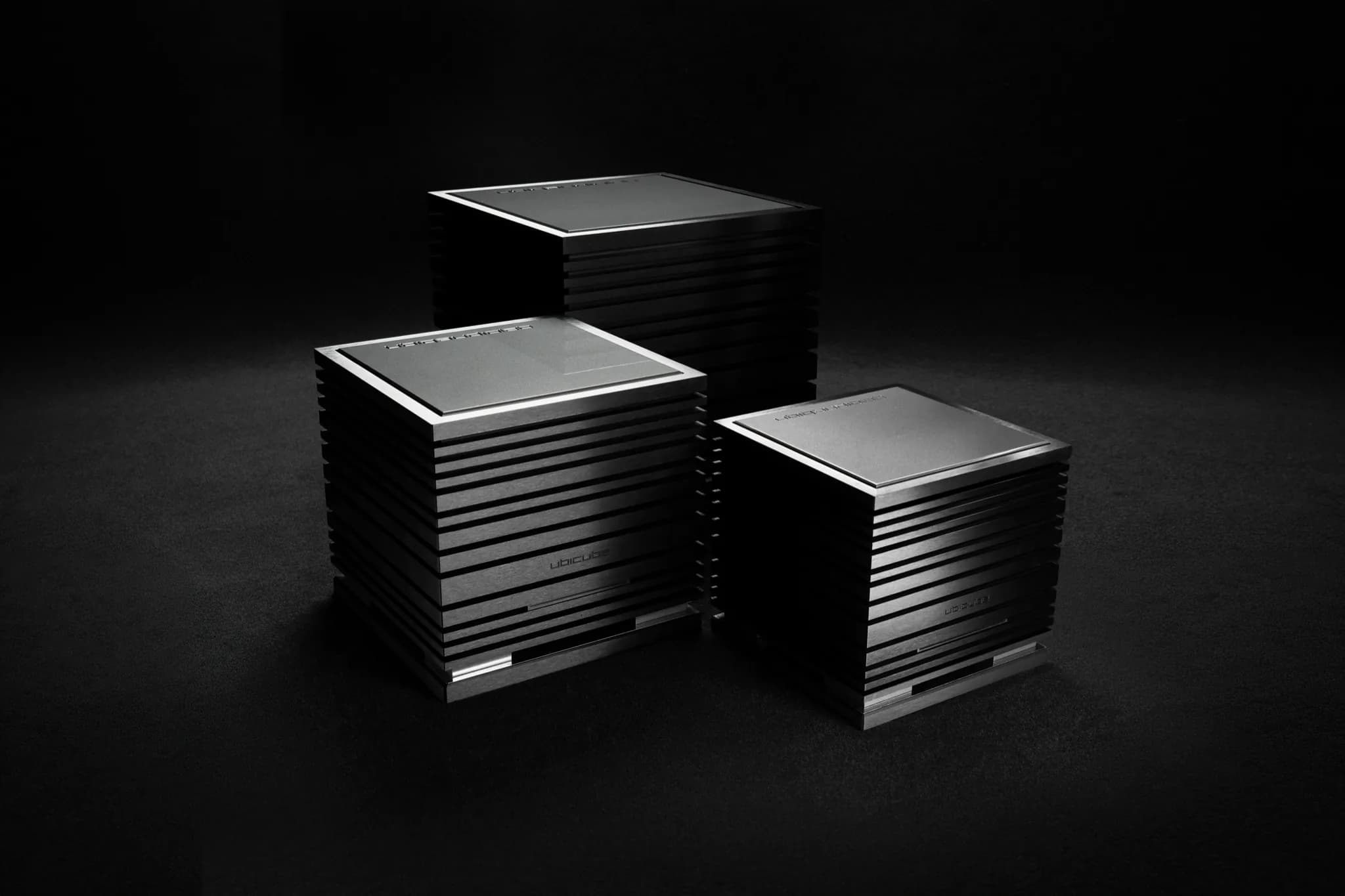Two UBICUBE power amplifiers with silver top plates and black cooling fins
