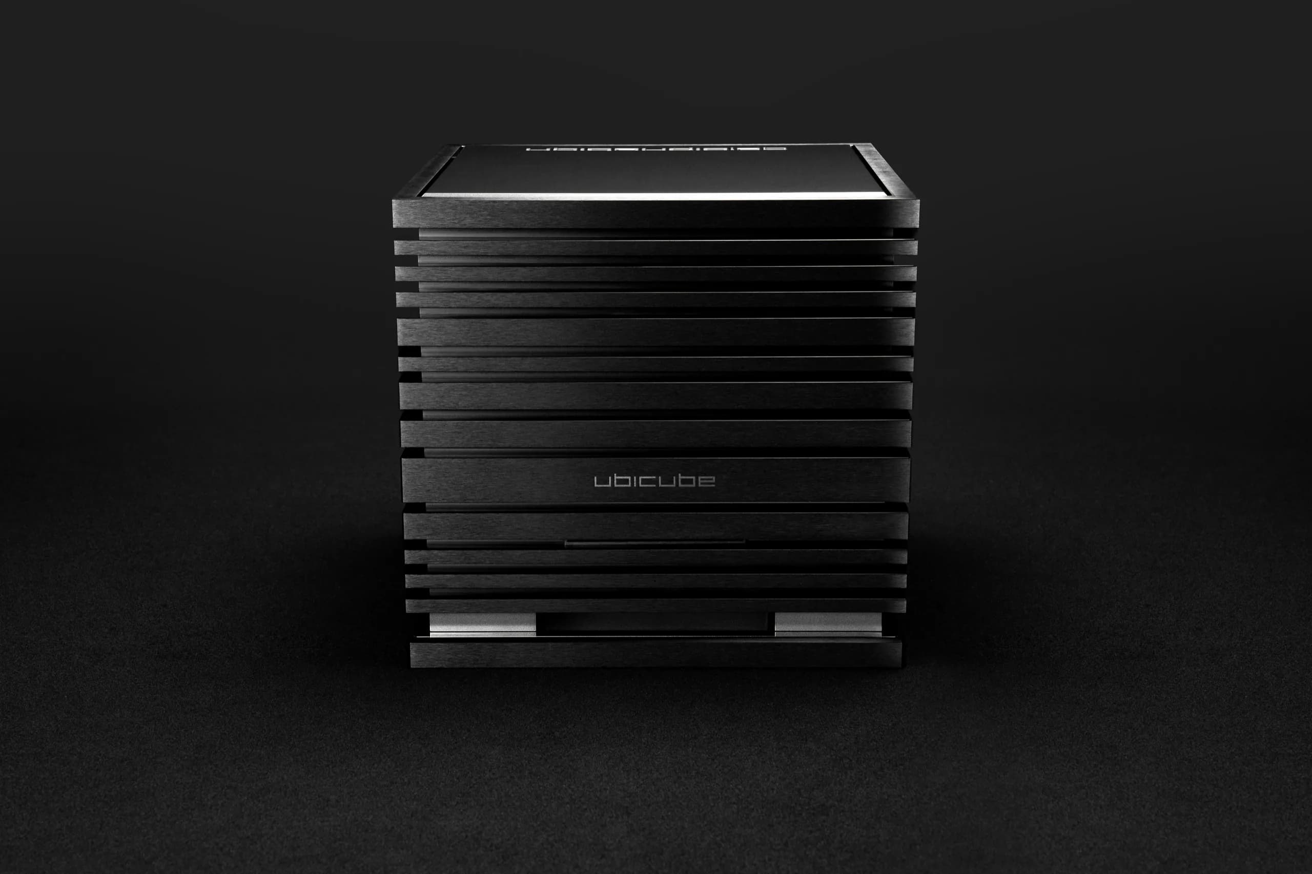 UBICUBE 700 amplifier standing in dim light, its blue status light glowing