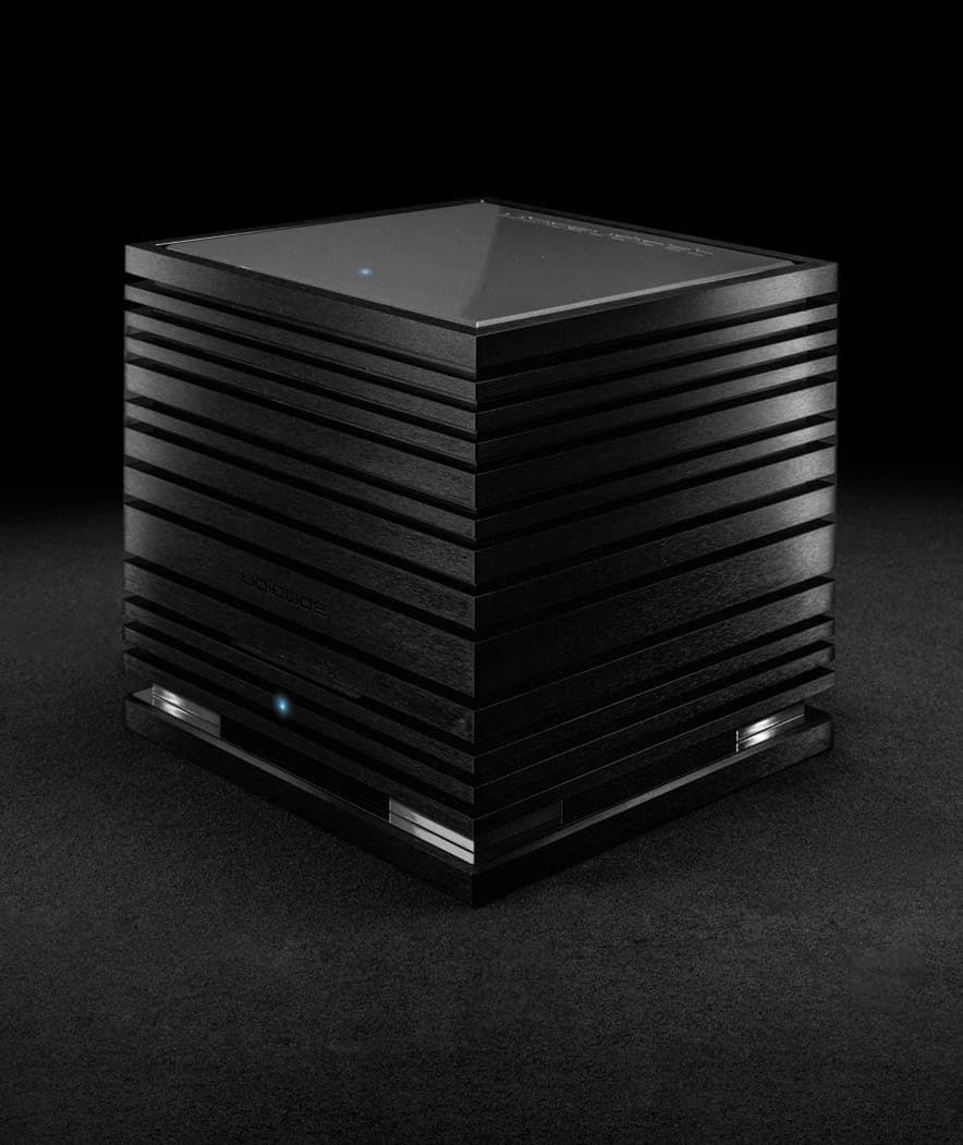 A UBICUBE amplifier on a dark ground, its blue status light glowing